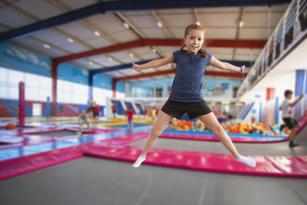 joyful little girl jumping on trampoline