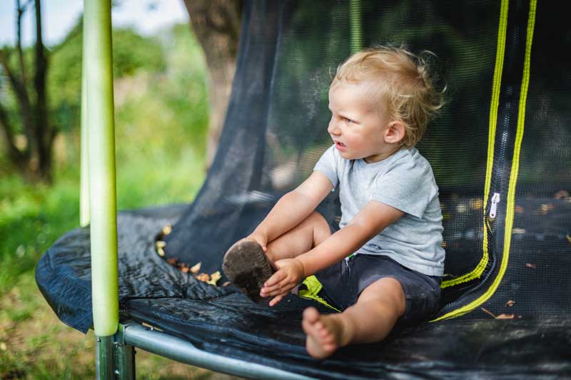 little childe prepares befor jumping on trampoline