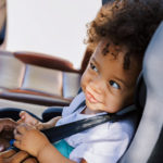 child car seat, mother buckling child in car seat