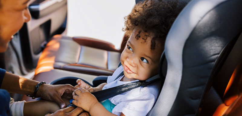 child car seat, mother buckling child in car seat