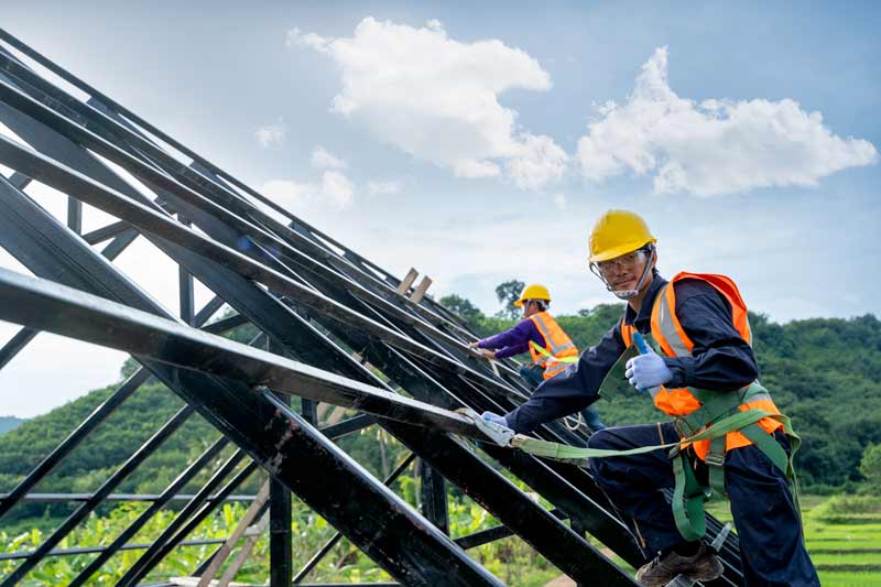 construction workers wearing safety harness protecting against fall