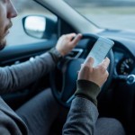 man driving distracted with mobile phone and smartphone app