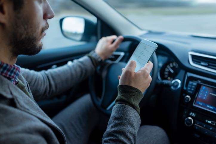 man driving distracted with mobile phone and smartphone app