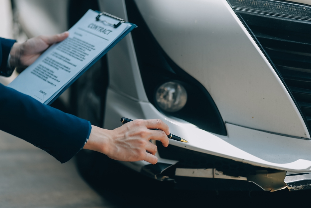Person inspecting damage to a car