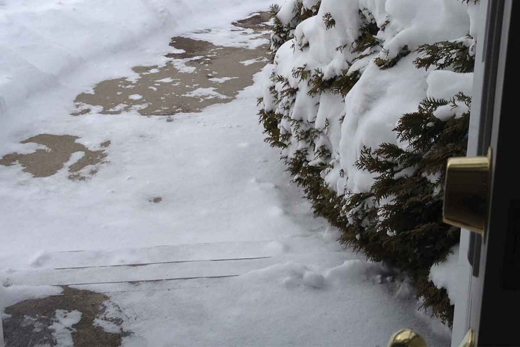 snow on steps and sidewalk looking out an open door