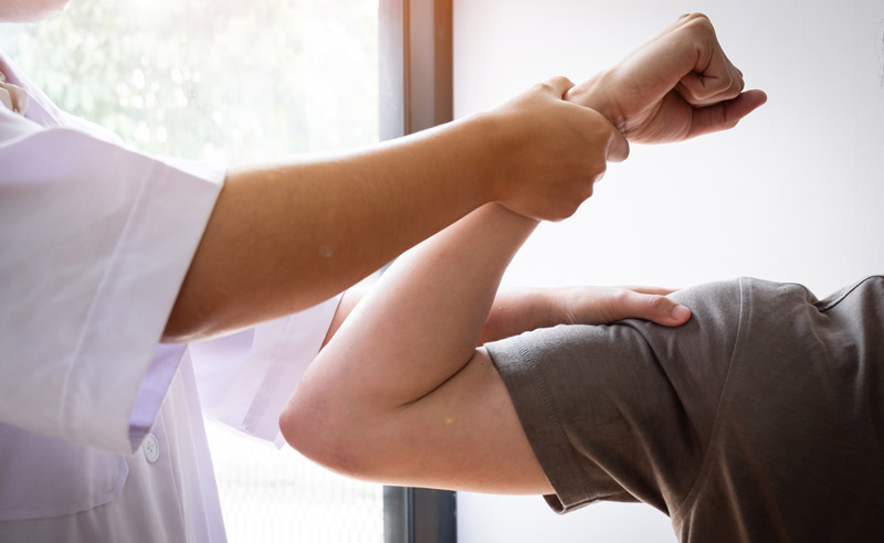 therapist testing strength of biceps muscle