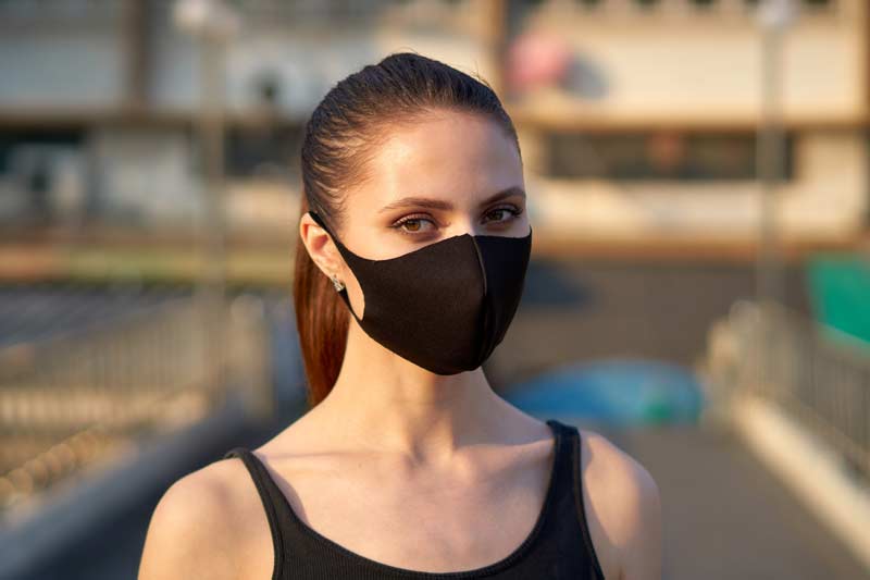woman wears a black mask to protect herself from the covid-19 coronavirus