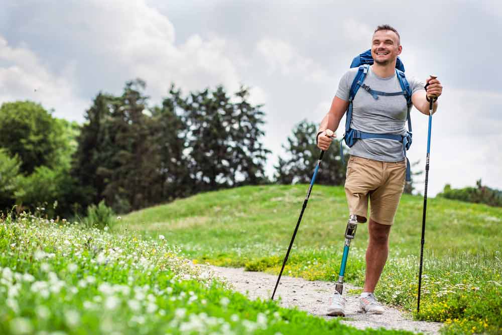 young man with prosthetic leg trying nordic walking